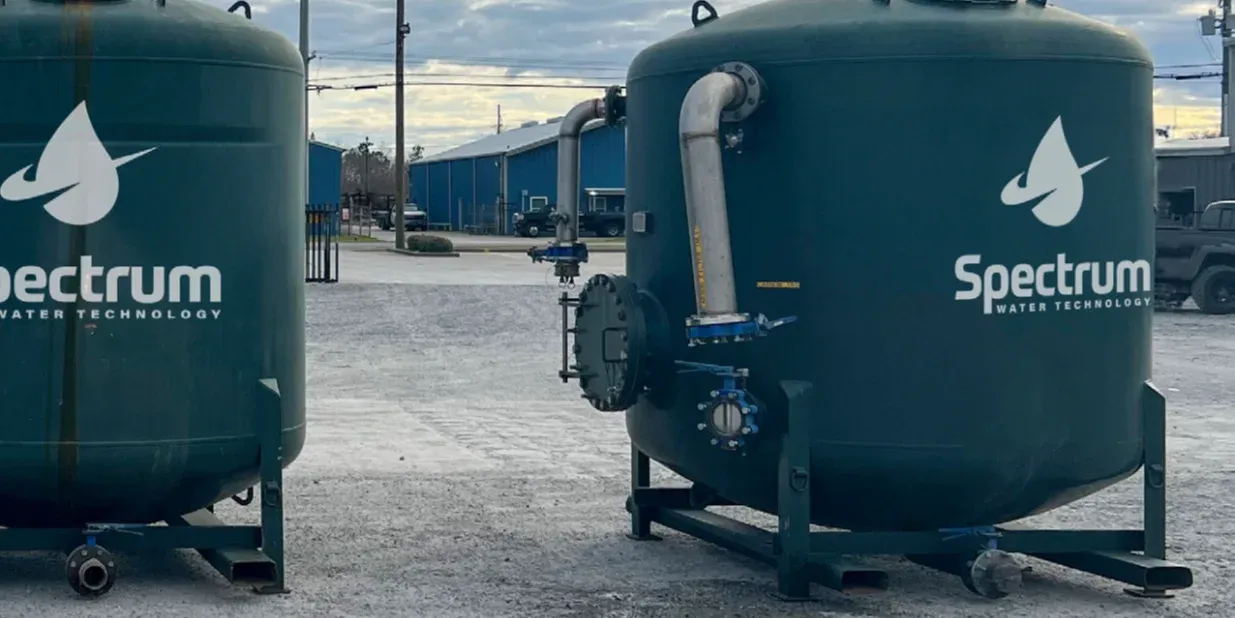 Two dark green Spectrum activated carbon pressure vessels standing in the yard