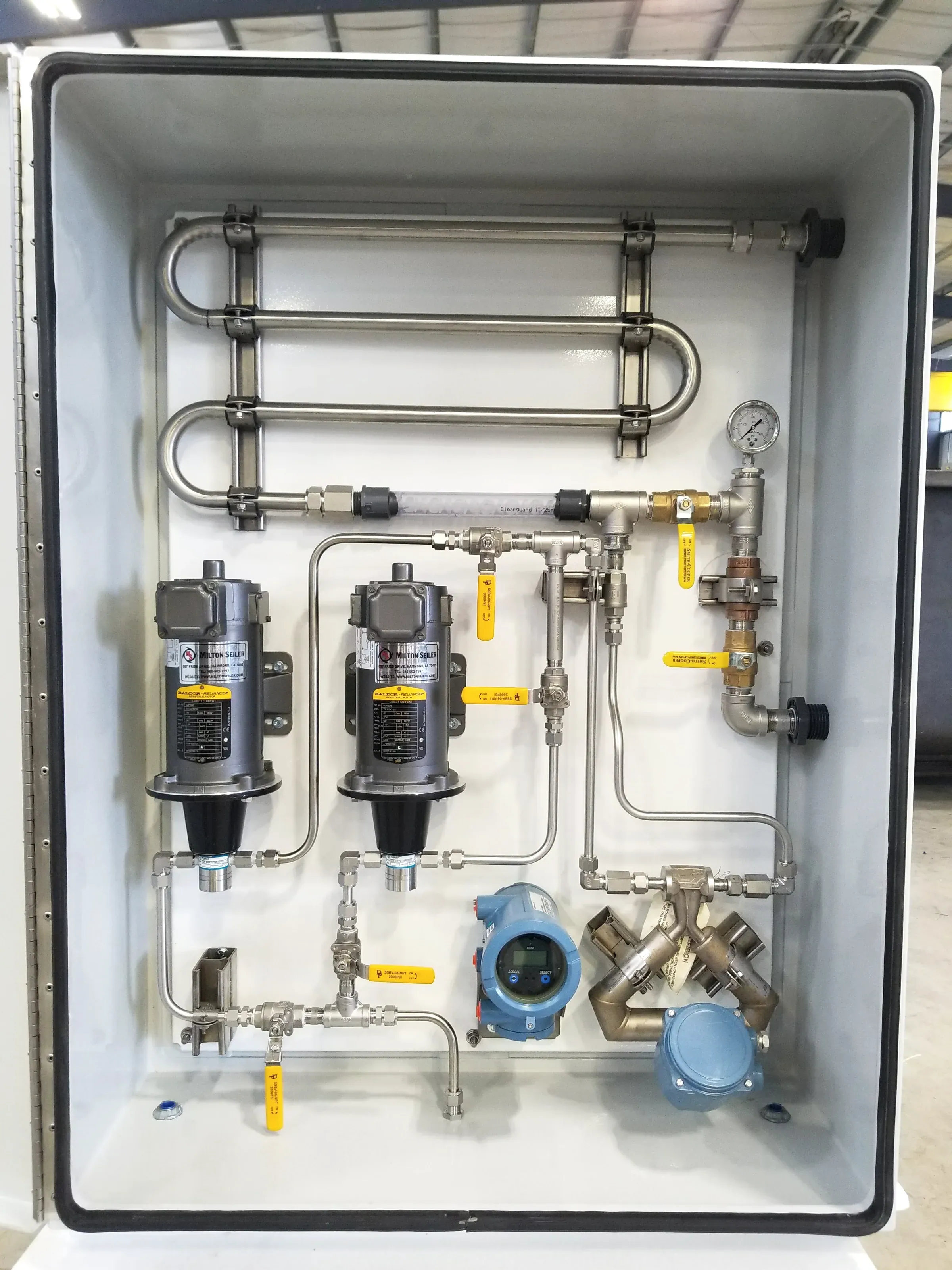 Chemical injection panel built into a white enclosure with twin metering pumps, stainless tubing and a flow transmitter