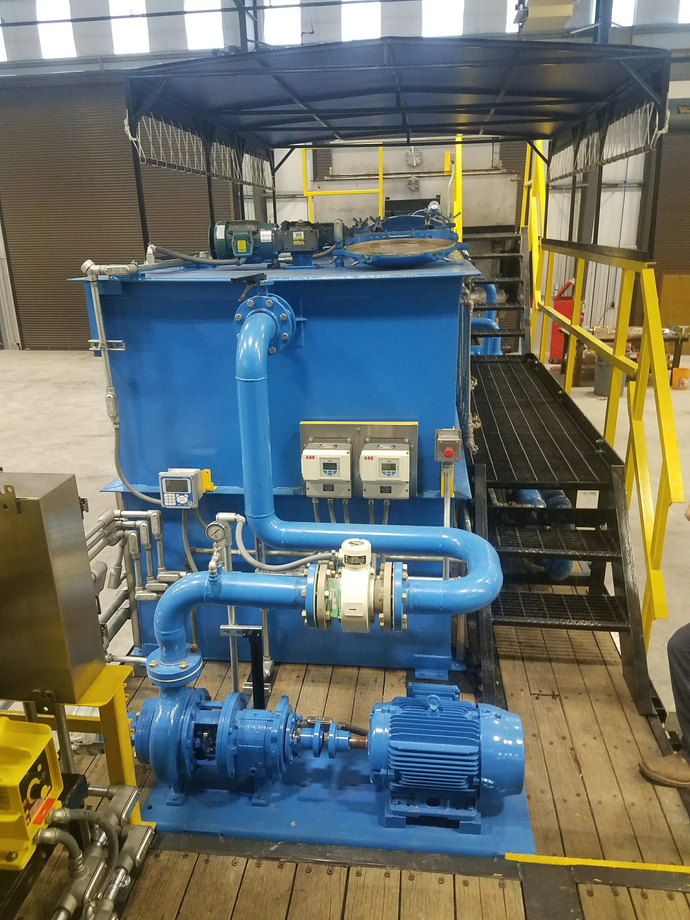 Blue DAF unit with recycle pump, motor, flow meter and drives mounted on a skid under a canopy
