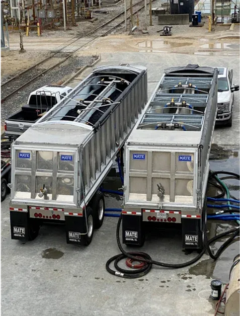 Two fast-flow end dump trailers rigged with drain hoses, dewatering on site