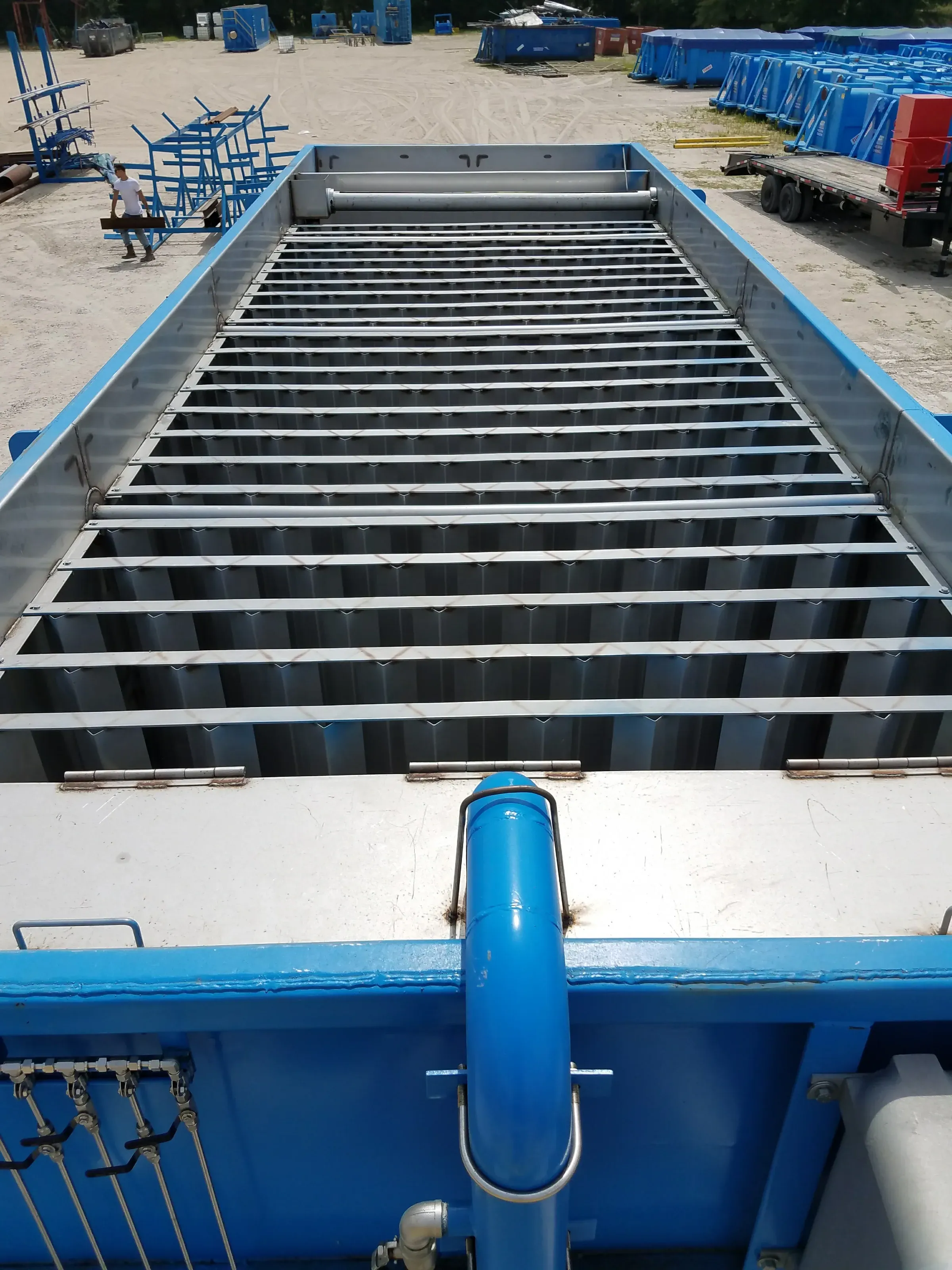 Looking down the length of an open blue lamella clarifier, stainless plate packs receding in parallel rows