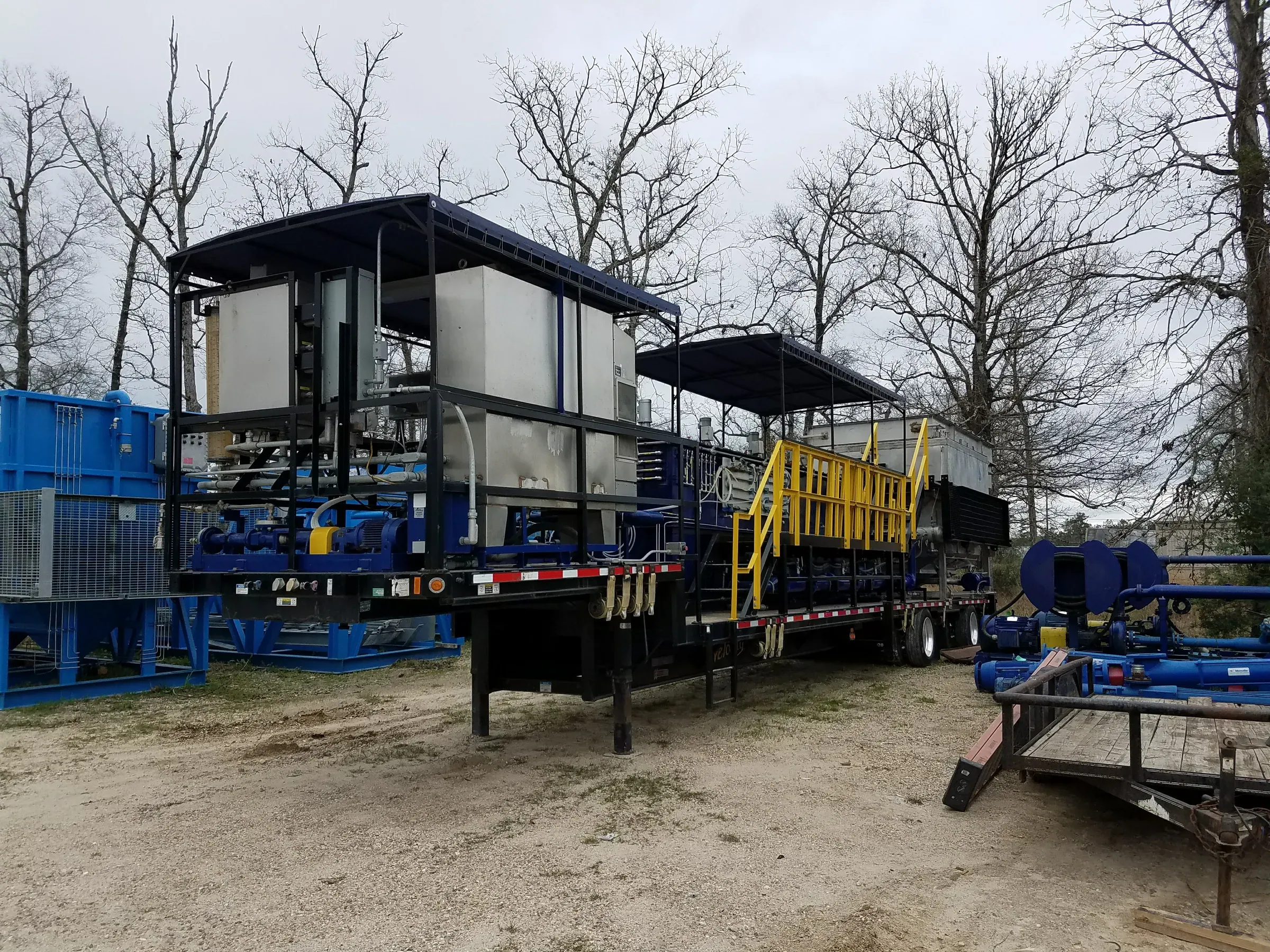 Two skid-mounted mobile water treatment trailers parked in a gravel yard