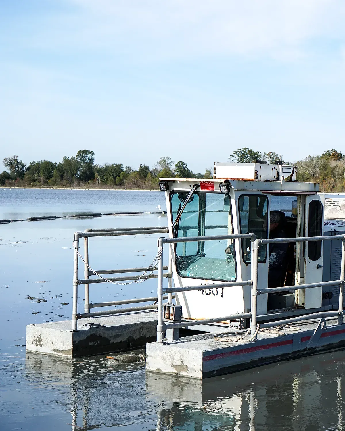 Pontoon dredge working across the surface of an industrial lagoon